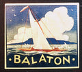 Balaton travel luggage label showing a red-hulled sailboat, white sails, clouds and yellow Balaton lettering