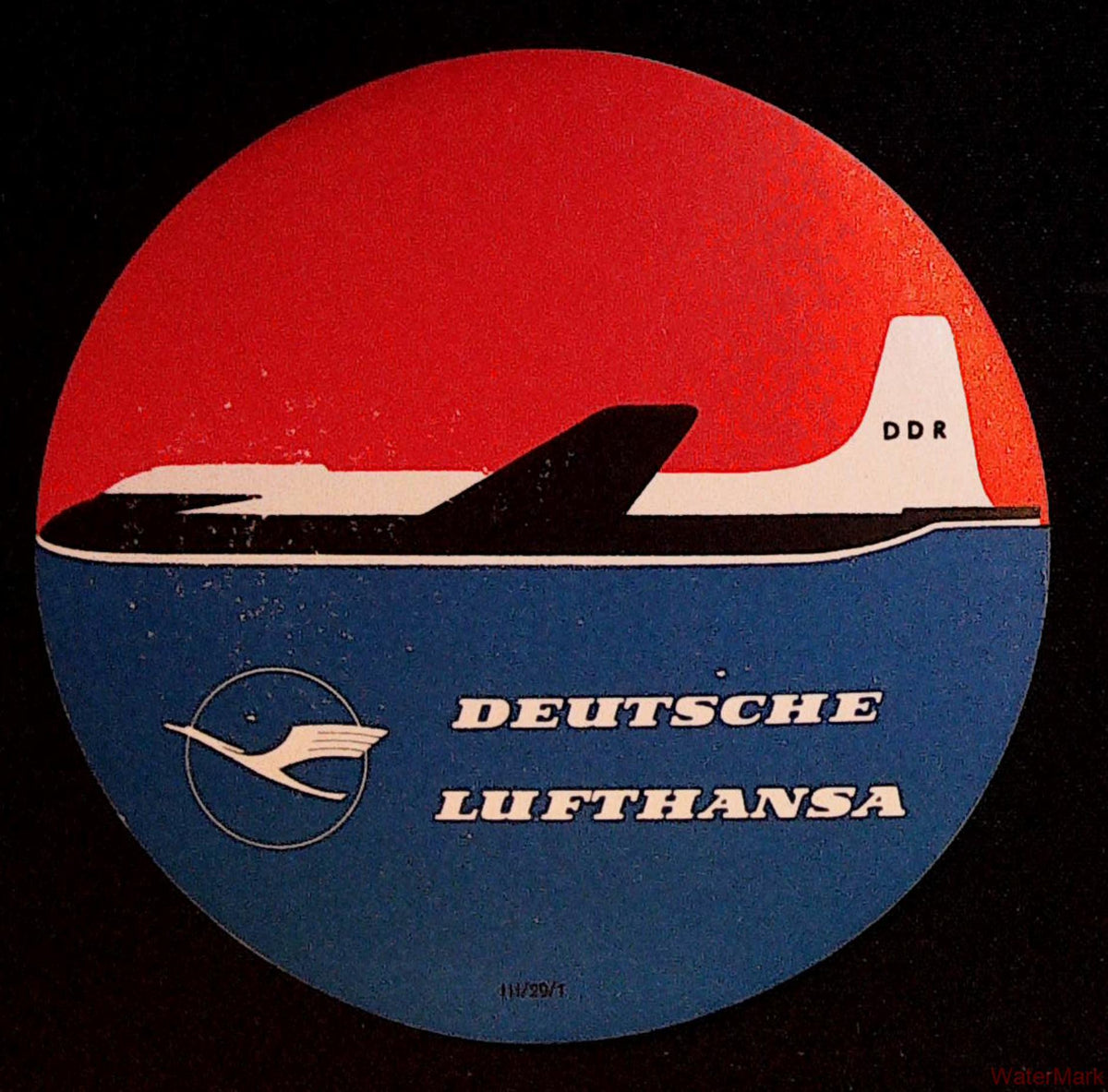 Circular Deutsche Lufthansa DDR airline luggage label with black-and-white aircraft on a red and blue background
