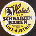 Circular yellow Hotel zum Schwarzen Bären Linz Austria luggage label with black bear shield and white border